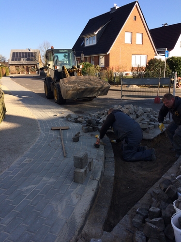 &Uuml;ber der Versorgungstrasse im Gehweg des Eichendorffweges verlegen Tiefbauarbeiter das neue Rechteckplaster