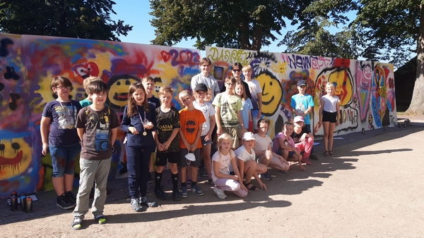 Bild vergrößern: Rund 20 Kinder gestalteten zusammen mit Graffiti-Künstlers Charlie Koch (Bildmitte) beim Abschlussfest der 'Ratzeburger Leseregatta' eine mobile Graffiti-Wand an der Ratzeburger Stadtbücherei