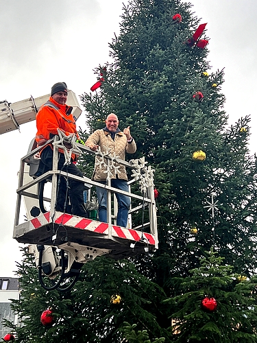 Bild vergrößern: Ratzeburgs Stadtpräsidenten Andreas von Gropper (re.) hilft einem Mitarbeiter des städtischen Bauhofes beim Schmücken des Weihnachtsbaumes auf dem Marktplatz.
